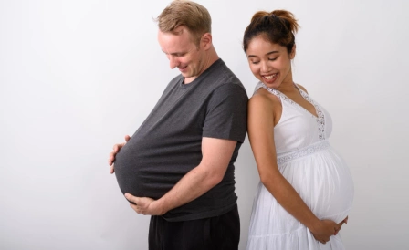 мужчина держит за живот беременную девушку