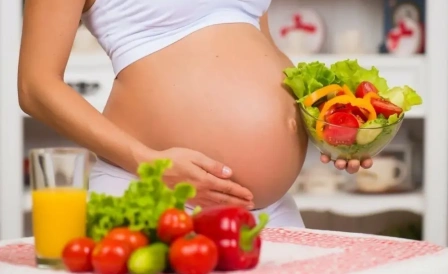 беременная девушка держит тарелку с овощами